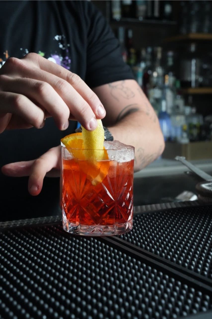 Negroni con twist d’arancia preparato al banco del Pappafico